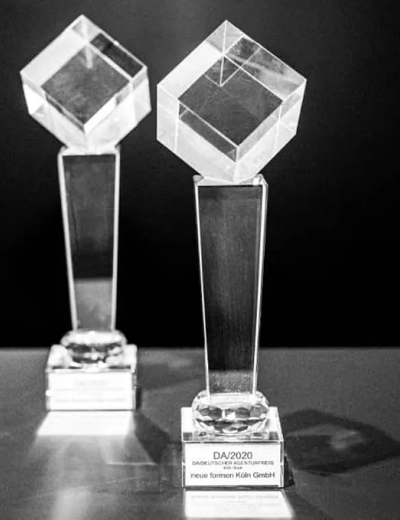 Zwei Awards aus Glas stehen nebeneinander
